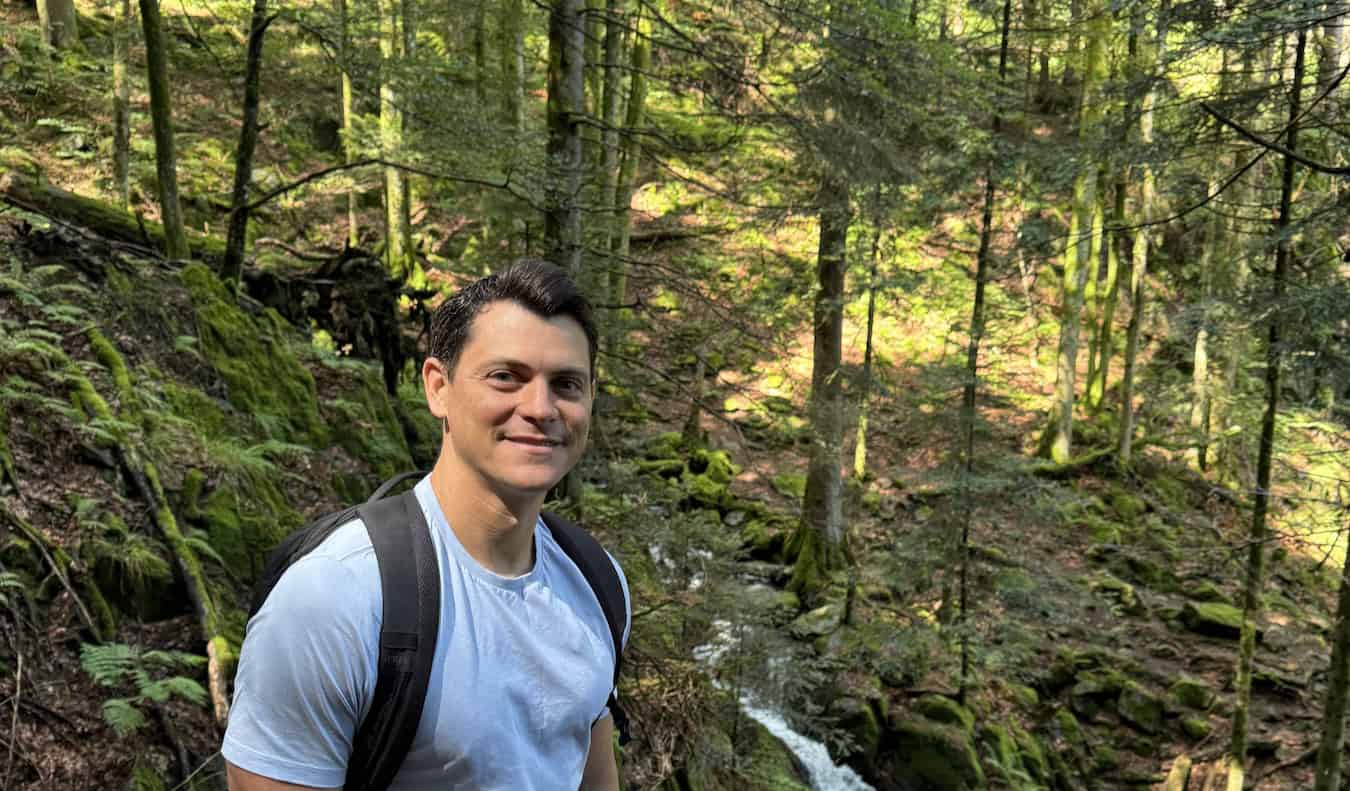 Nomadic Matt hiking through the lush forests of the Black Forest region in Germany